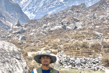 Samar Baniya standing in front of majestic Himalayas.