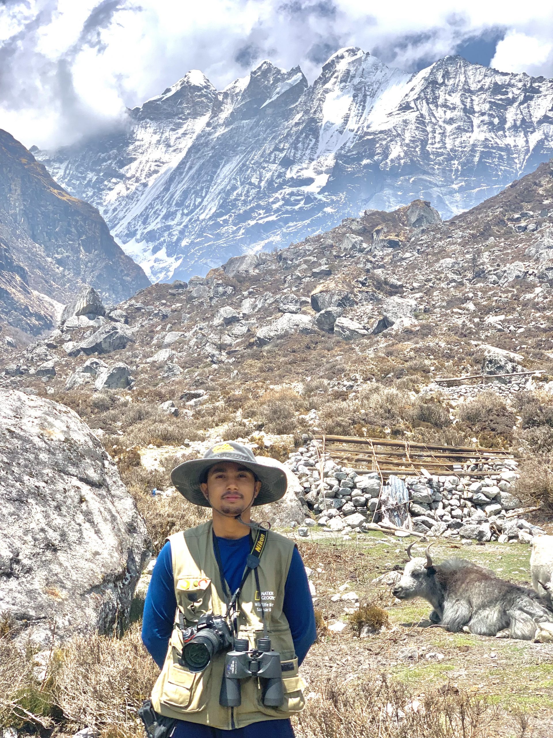 Samar Baniya standing in front of majestic Himalayas.